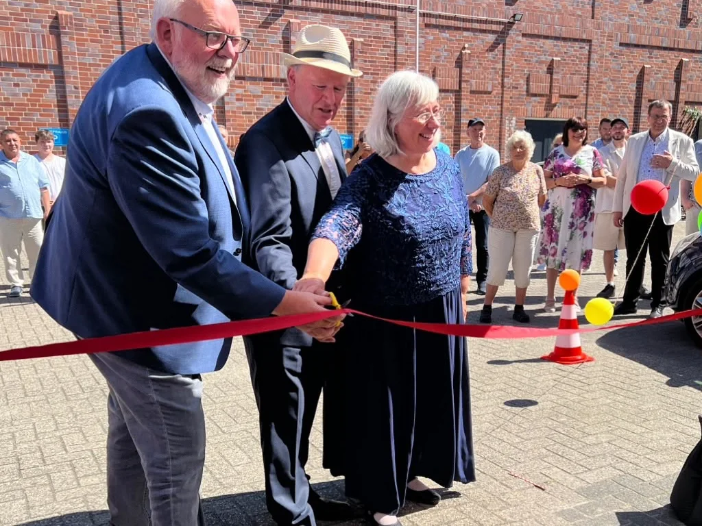 Durchschneiden des roten Bandes vor dem neuen Gemeindehaus an der M&uuml;hlenmathe
